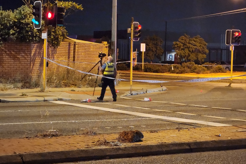 A police officer at the scene of an accident on a road at night