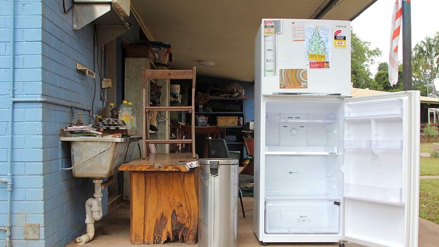 A photo showing some stacked up furniture and an open fridge being aired out.