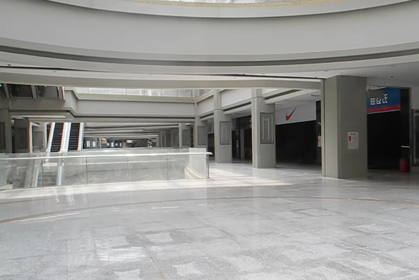 The interior of a shopping centre. All the shops look closed and there are no people around.