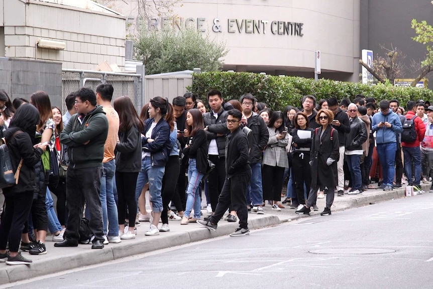 People lining up on the side of road