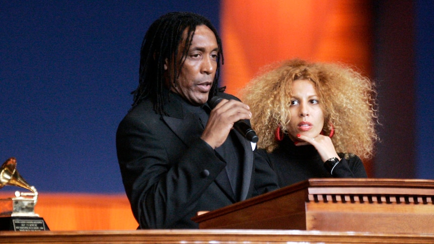 Ronnie Turner holding a microphone next to his wife Afida. 