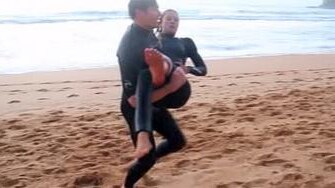 Kirra-Belle Olsson is carried from the surf after the shark attack at Avoca Beach