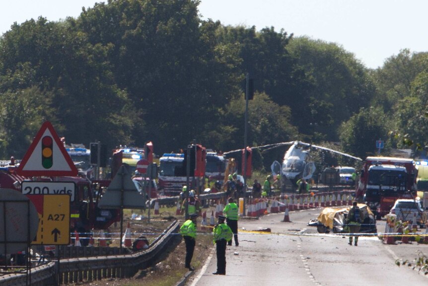 Police and members of the emergency services work at the scene of a plane crash at Shoreham Air Show