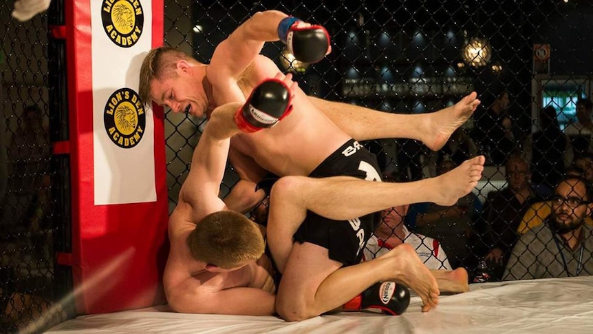 Two men wrestling and fighting in a cage