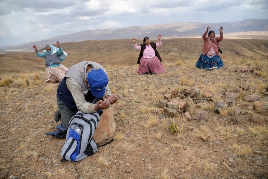 People kneel and pray on the ground. 