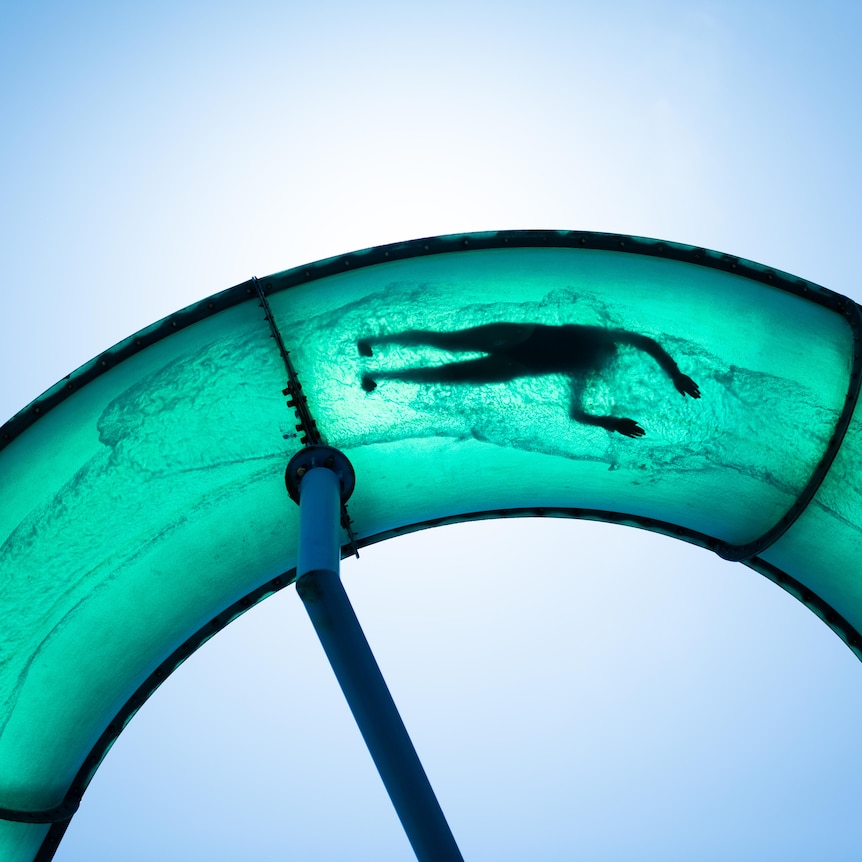 A person on a curved waterslide pictured from underneath
