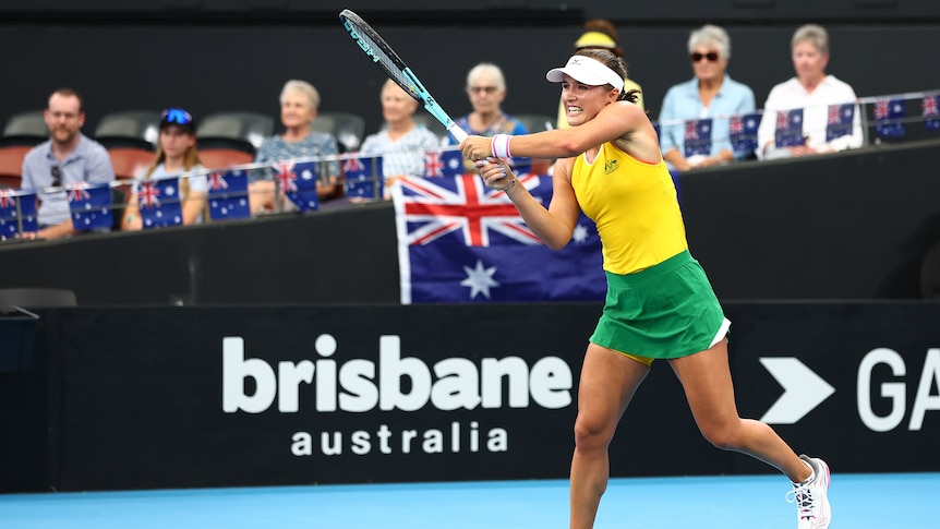 An Australian tennis player hits a double-handed backhand return in an international women's teams event.