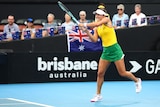 An Australian tennis player hits a double-handed backhand return in an international women's teams event.