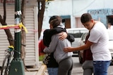 Residents hug after a building was damaged by an earthquake that struck off the southern coast of Mexico