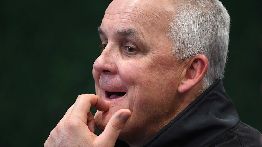 Anthony Griffin holding his chin during a Penrith Panthers media conference.