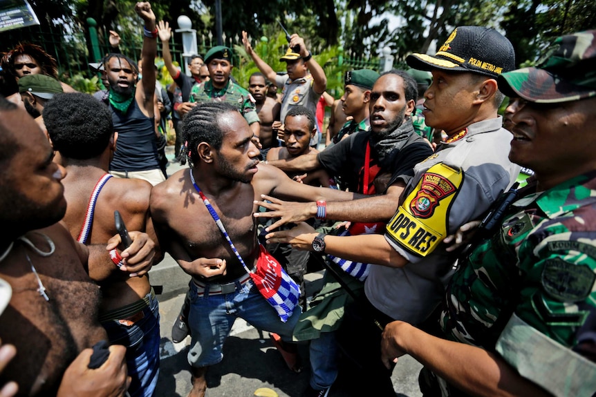 Papuan activists scuffle with police and soldiers during a rally near the presidential palace in Jakarta, Indonesia.