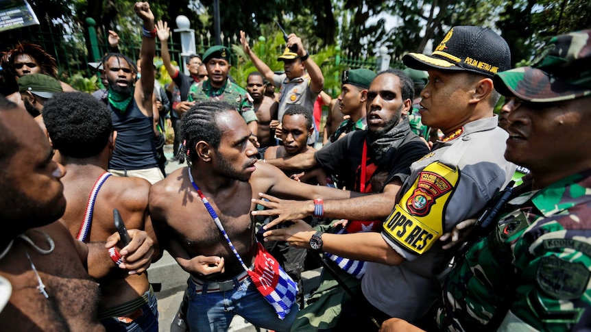 Papuan activists scuffle with police and soldiers during a rally near the presidential palace in Jakarta, Indonesia.