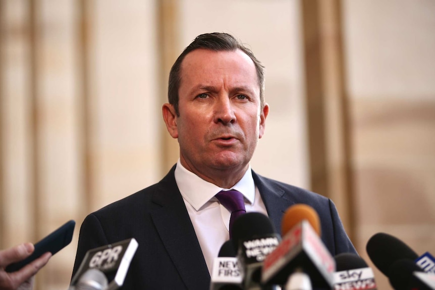 Western Australian Premier Mark McGowan stands in front of several microphones outside WA Parliament