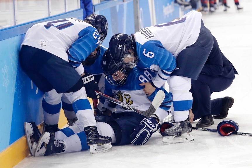 Ronja Savolainen is helped by her teammates on the ice after her crash.