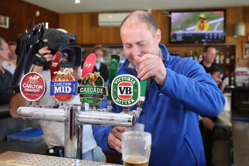 Josh Frydenberg pours beers at Auburn Bowls Club.