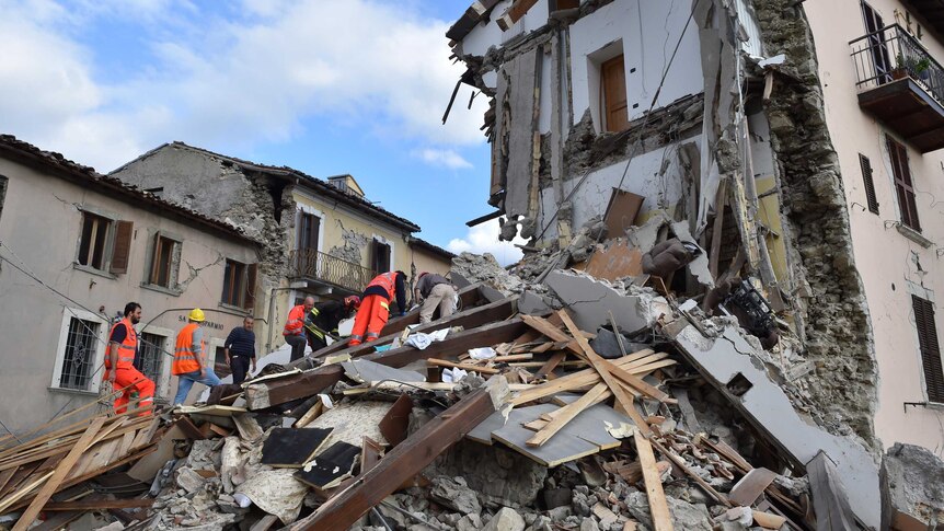 Rescuers search among damaged buildings after a strong earthquake hit central Italy, in Arquata del Tronto on August 24, 2016.
