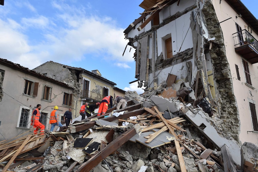 Rescuers search among damaged buildings after a strong earthquake hit central Italy, in Arquata del Tronto on August 24, 2016.