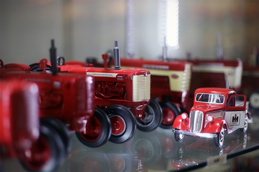 A collectable Case International tractor sits on a shelf among hundreds of other model tractors.