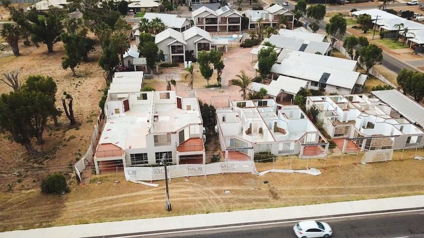 Aerial view of destroyed holiday accommodation, with missing roofs.