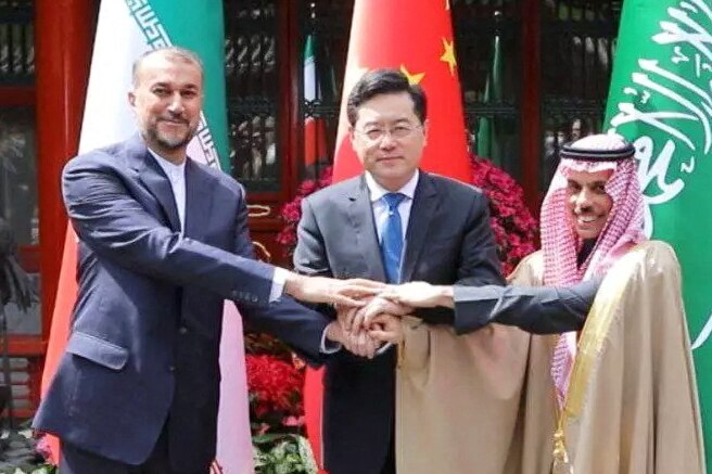 Three man gather hands together in handshake for a photo call.