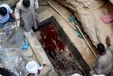 Workers unearth coffin containing three mummies with sewage water and bones inside in Alexandria.