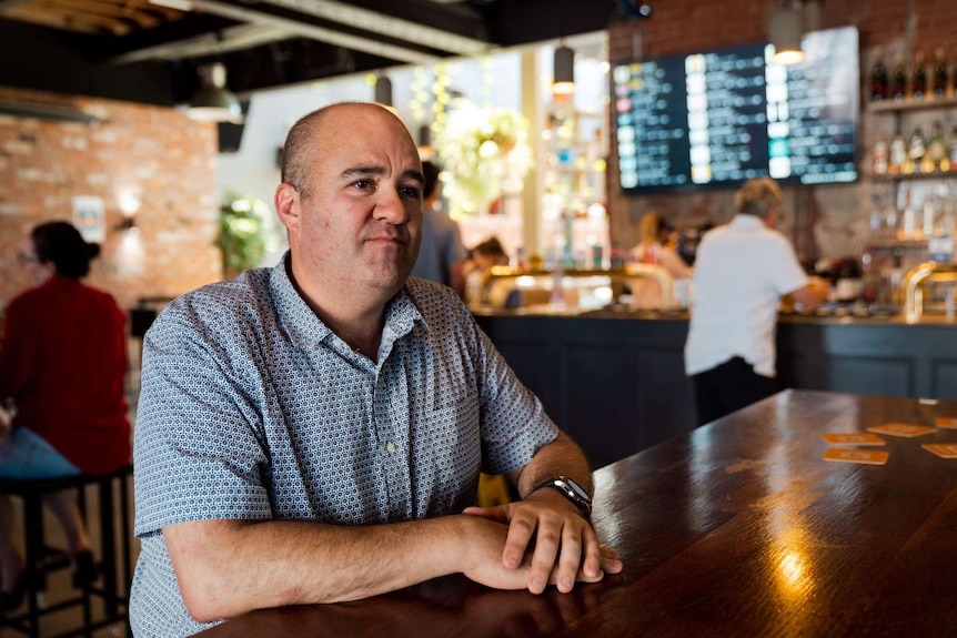 Wembley Hotel owner Kane Mansfield sitting at a bar.