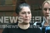 Roberta Williams is led away from her Melbourne home by detectives.