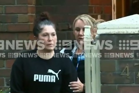 Roberta Williams is led away from her Melbourne home by detectives.