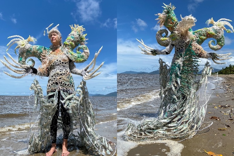 A lady on the beach in a costume made out of ghost nets