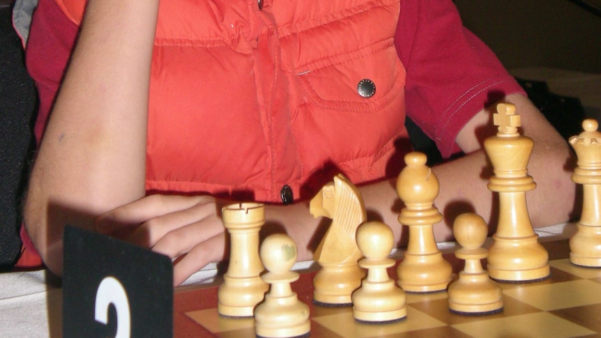 Young chess player Anton Smirnov studies the board.