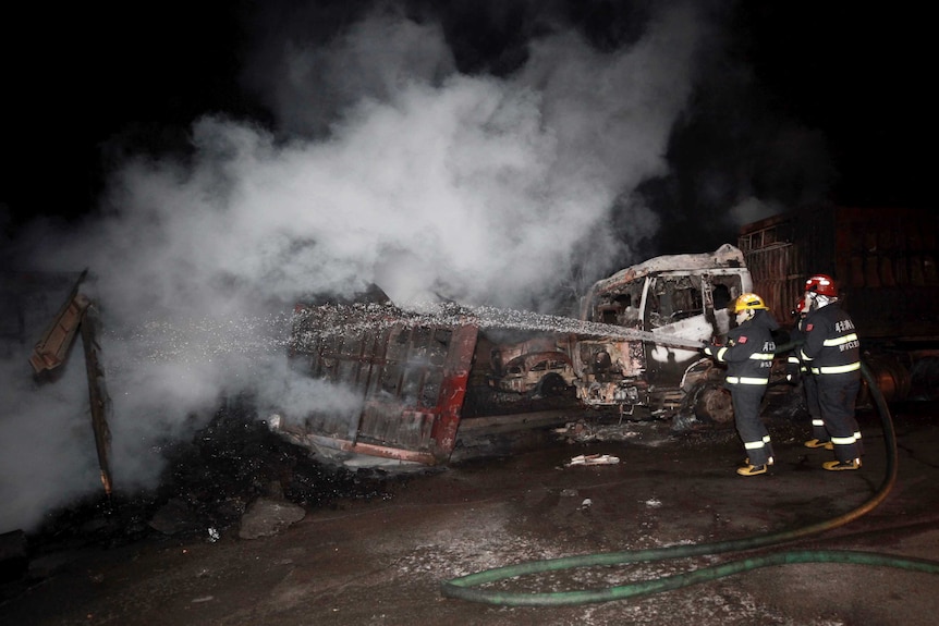 Firefighters try to extinguish burning vehicles in the aftermath of an explosion at a chemical plant in north-eastern China.