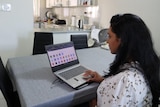 a woman studying at home on a laptop