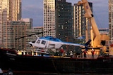 The helicopter that crashed into the East River in New York is hoisted from the water