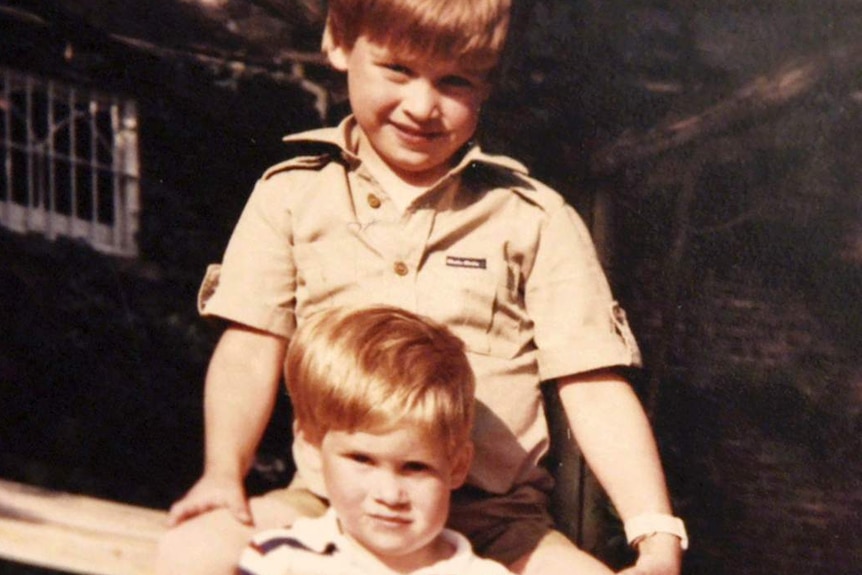 Prince William and Prince Harry sit on a picnic bench together.