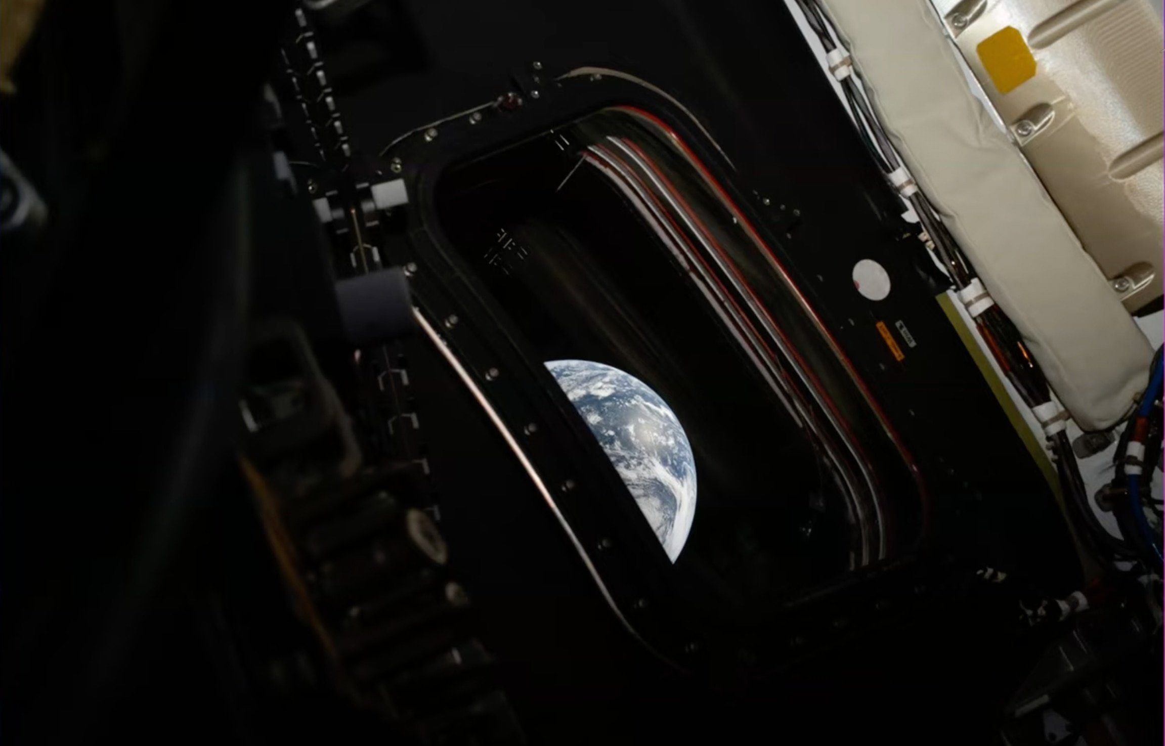 This image shows a curved slice of Earth in a space capsule window.