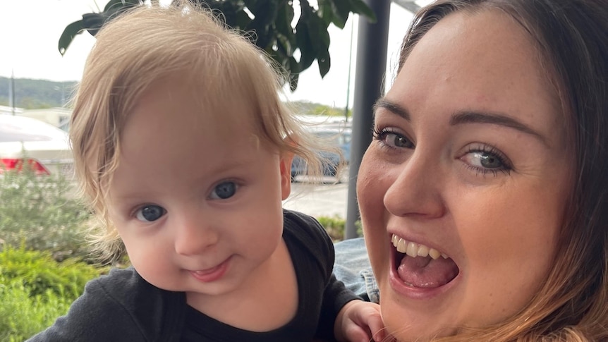 Caitlyn Sheehan holds her son Lucas while they smile.