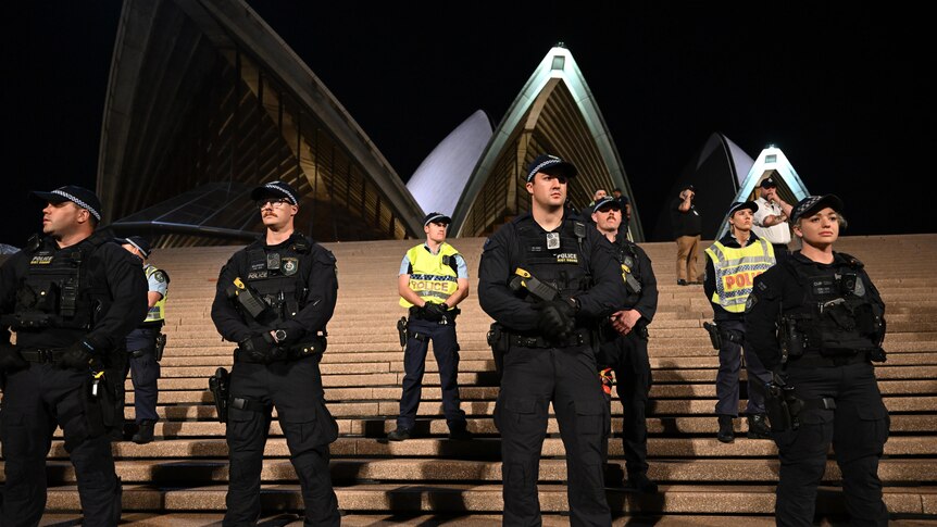 Police in uniform line the forecourt steps of the Sydney Opera House with building in background