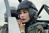 Sineenat Wongvajirapakdii in a helmet and uniform flying a fighter jet.