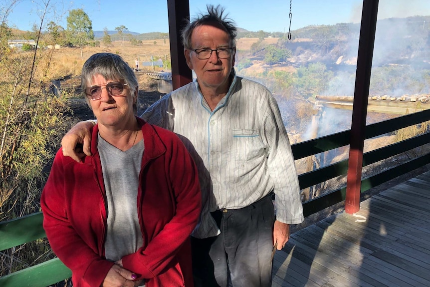 Dianne and Vince Hollis standson the veranda of their home after bushfire damaged a rail bridge.