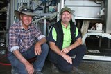 Darrell and Greg Dennis pose in front of their robotic milking machine.