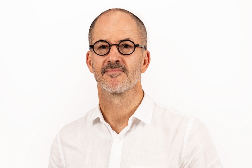 A man wearing a white shirt and glasses.