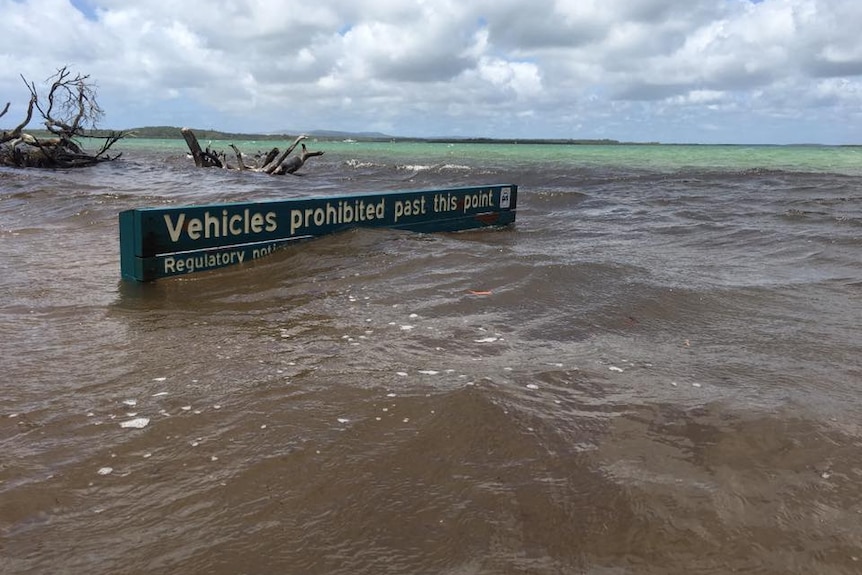 A sign at Inskip Point is almost under water as a high tide impacts the area.