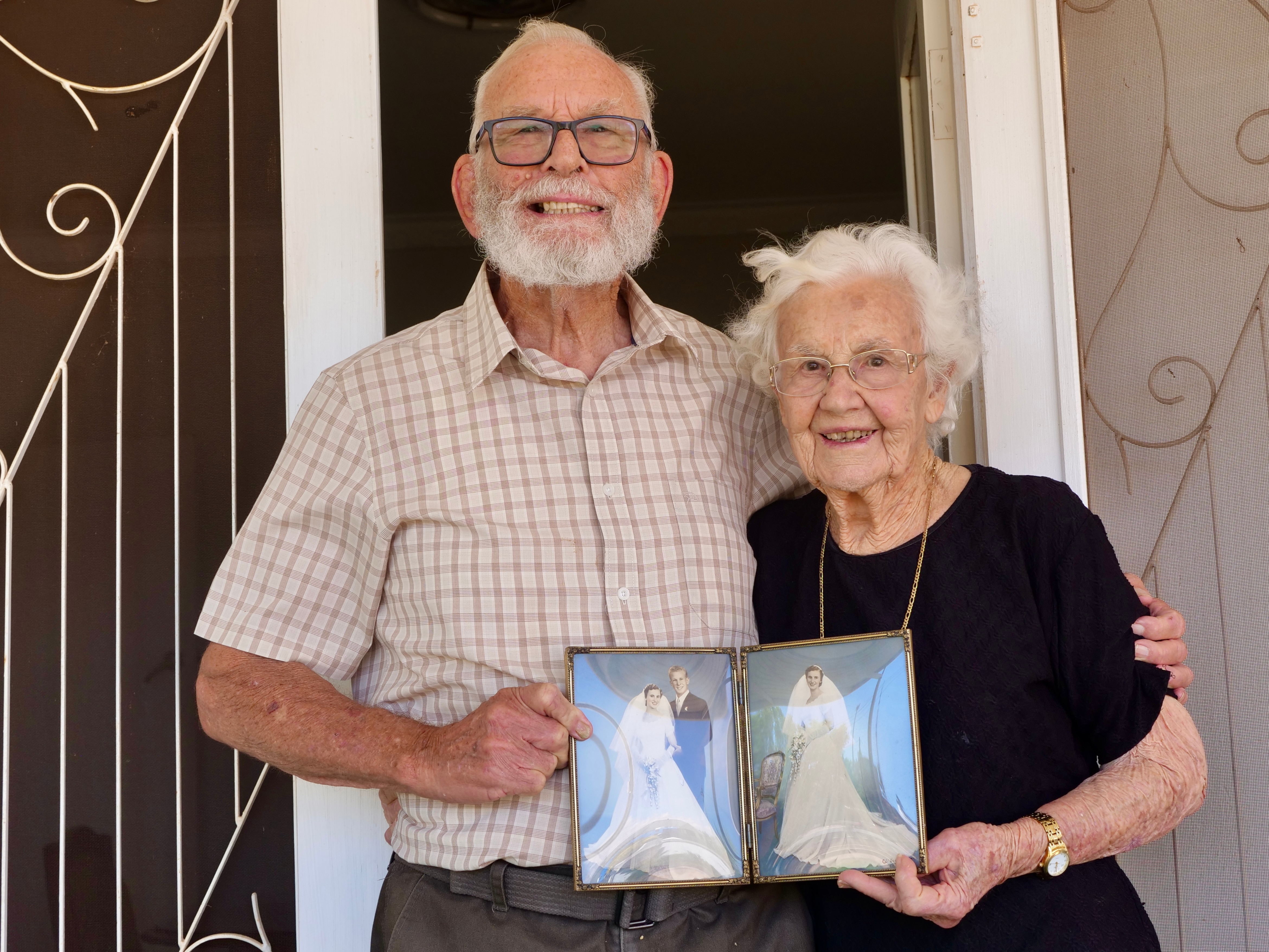Una pareja de ancianos se encuentra en la puerta de entrada.
