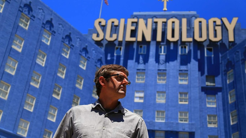 Portrait of Louis Theroux standing in front of the Church of Scientology in Los Angeles.