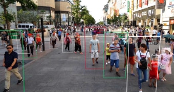 A digitally enhanced photo shows people walking down a street with graphics over them.