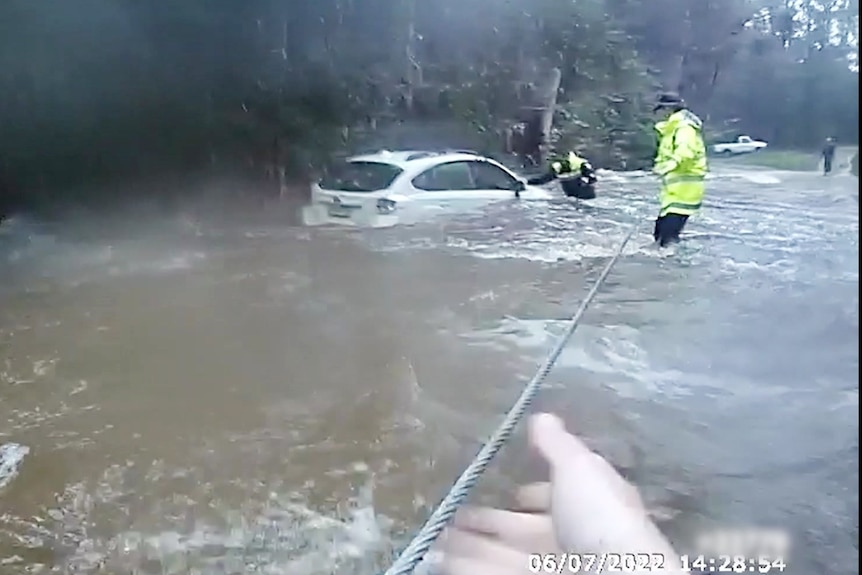 Police rescuing a woman trapped in a car