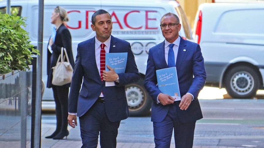 Tom Koutsantonis and Jay Weatherill walking outdoors.