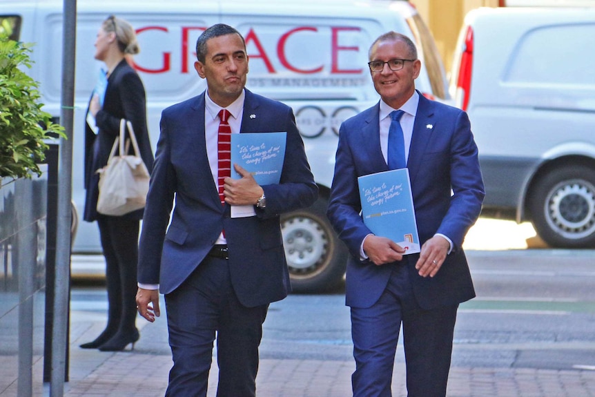 Tom Koutsantonis and Jay Weatherill walking outdoors.