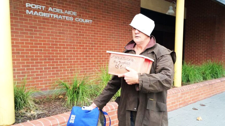 David Granger arrives at court wearing the container he used during the alleged incident.