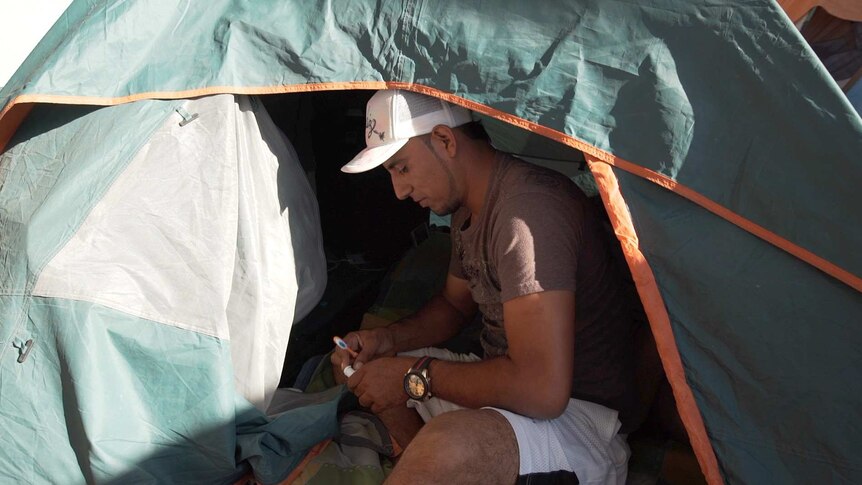 El Salvadorian migrant Herbert Zometa sitting in his tent at a shelter in Tijuana